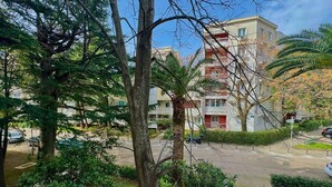 A residential building with multiple balconies, surrounded by trees and greenery. - Family two bedroom apartment Slavia (Budva)