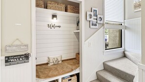 A home interior with a built-in bench under a 'Welcome' sign, a 'Did someone say WALK?' sign, and a window with blinds. - Beach Club Bliss Villa Steps to Sand, Shops & Sunshine (Hilton Head Island)