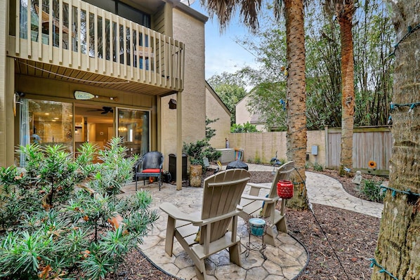 Un espace patio aménagé avec du mobilier d’extérieur, une terrasse en bois et une vue sur la maison.