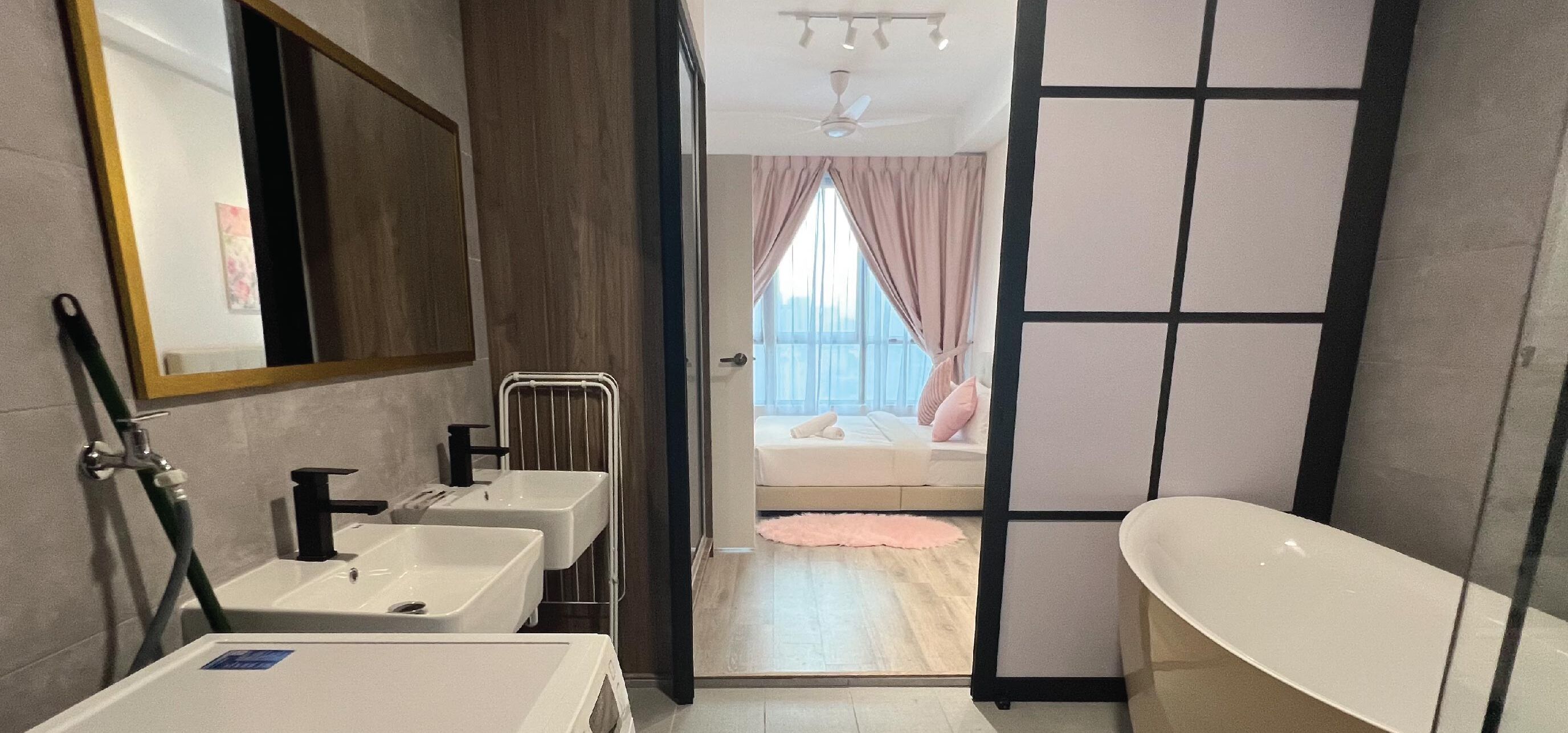 Un baño moderno con dos lavamanos, una bañera y un espejo grande.