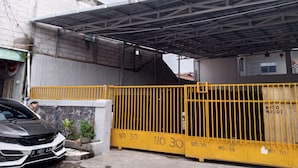Una entrada cerrada con techo de metal y un portón amarillo identificado con 