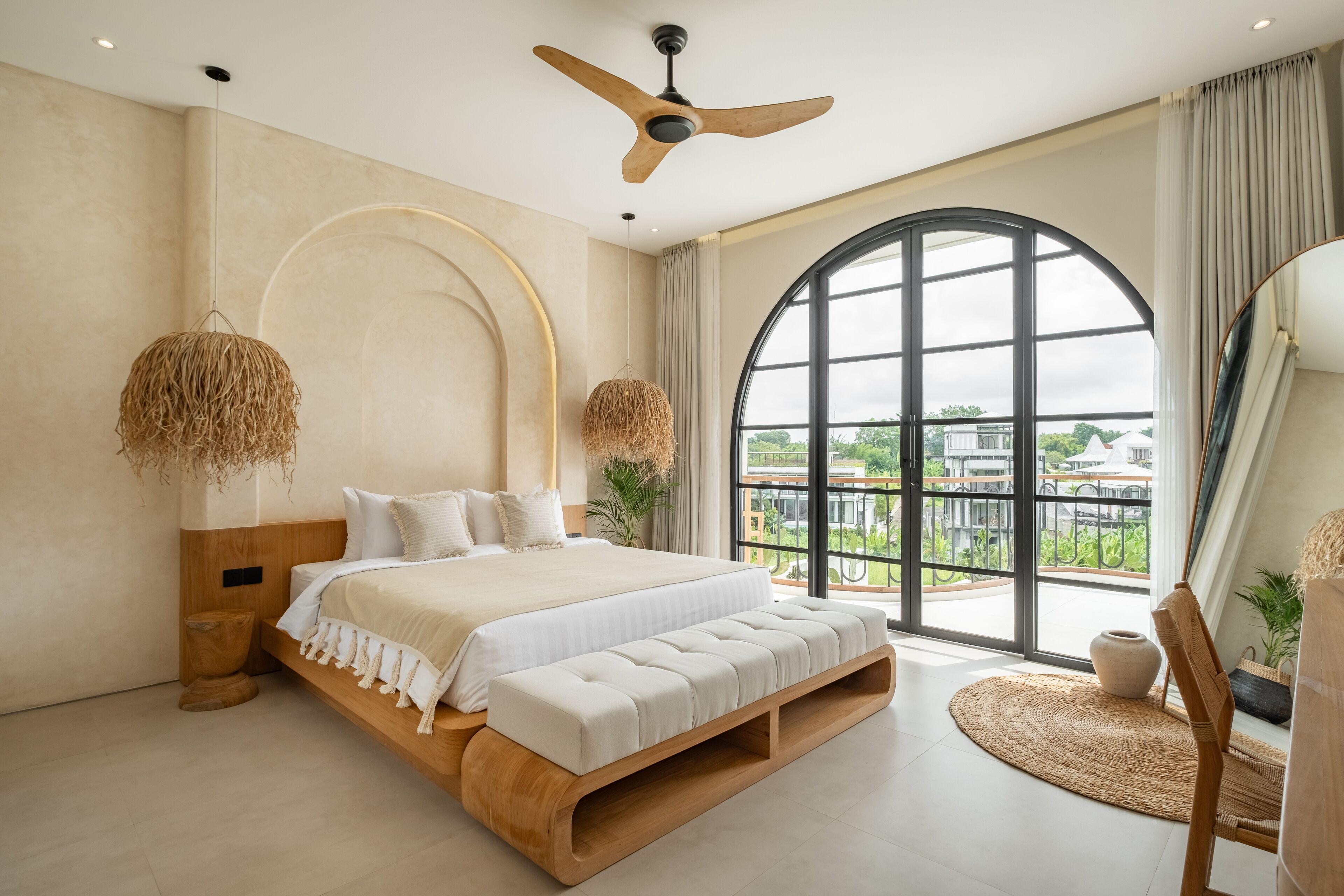 Un dormitorio moderno con una cama grande, un ventilador de techo y vistas por una ventana amplia.