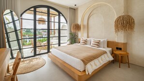 Un dormitorio moderno con una cama grande, un ventilador de techo y vistas al exterior a través de un ventanal.