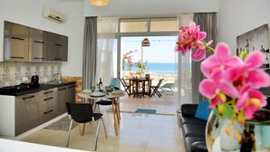 A modern kitchen with a dining area and a view of the beach. - Studio Mare Faliraki, Beachfront (Faliraki)