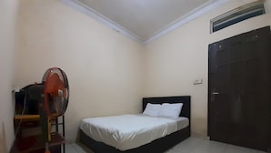 A bedroom with a bed, a fan, a door, and a tiled floor. - Hotel O Intan HomestayNearAnugrah Sinar Lautan (Batam)