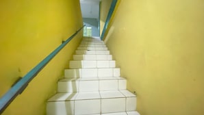 A staircase with white steps and yellow walls, leading to a door at the top. - Hotel O Intan HomestayNearAnugrah Sinar Lautan (Batam)