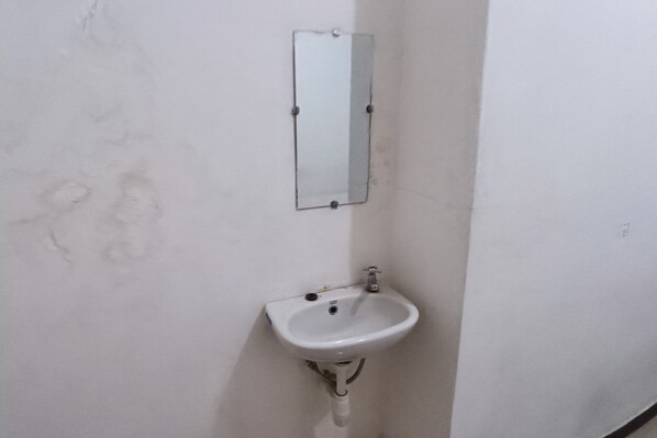 A white bathroom with a rectangular mirror and a pedestal sink. - Hotel O Aulia Residence (Rembang)