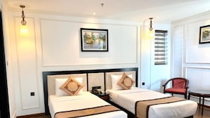 Una habitación de hotel con dos camas, una silla y una mesa.
