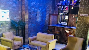 A bar area with sofas and a bar counter. - Mclorrets Suites (Enugu)