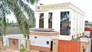 A building with a sign reading "MCLORRETS" and a gated entrance. - Mclorrets Suites (Enugu)
