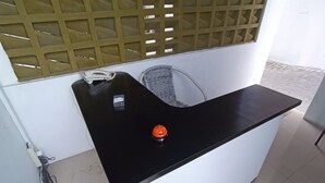 A reception desk with a black countertop, a telephone, and a red button. - Hotel O Bumi Tenang Homestay (Salatiga)
