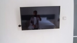 A flat-screen TV mounted on a white wall in a room. - Hotel O Bumi Tenang Homestay (Salatiga)