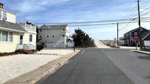 Une rue résidentielle bordée de maisons, avec un panneau de signalisation et des poteaux électriques.
