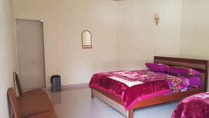 Un dormitorio con cama, una silla, un escritorio y una puerta.