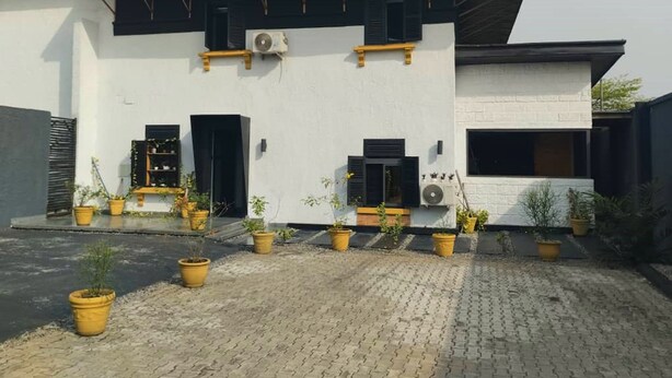 A modern building with a flat roof, large windows, and potted plants. - The Crib-Artist Residence (Port Harcourt)