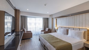 A modern hotel room with a large bed, a desk, and a seating area. - Belenli Resort Hotel  (Serik)