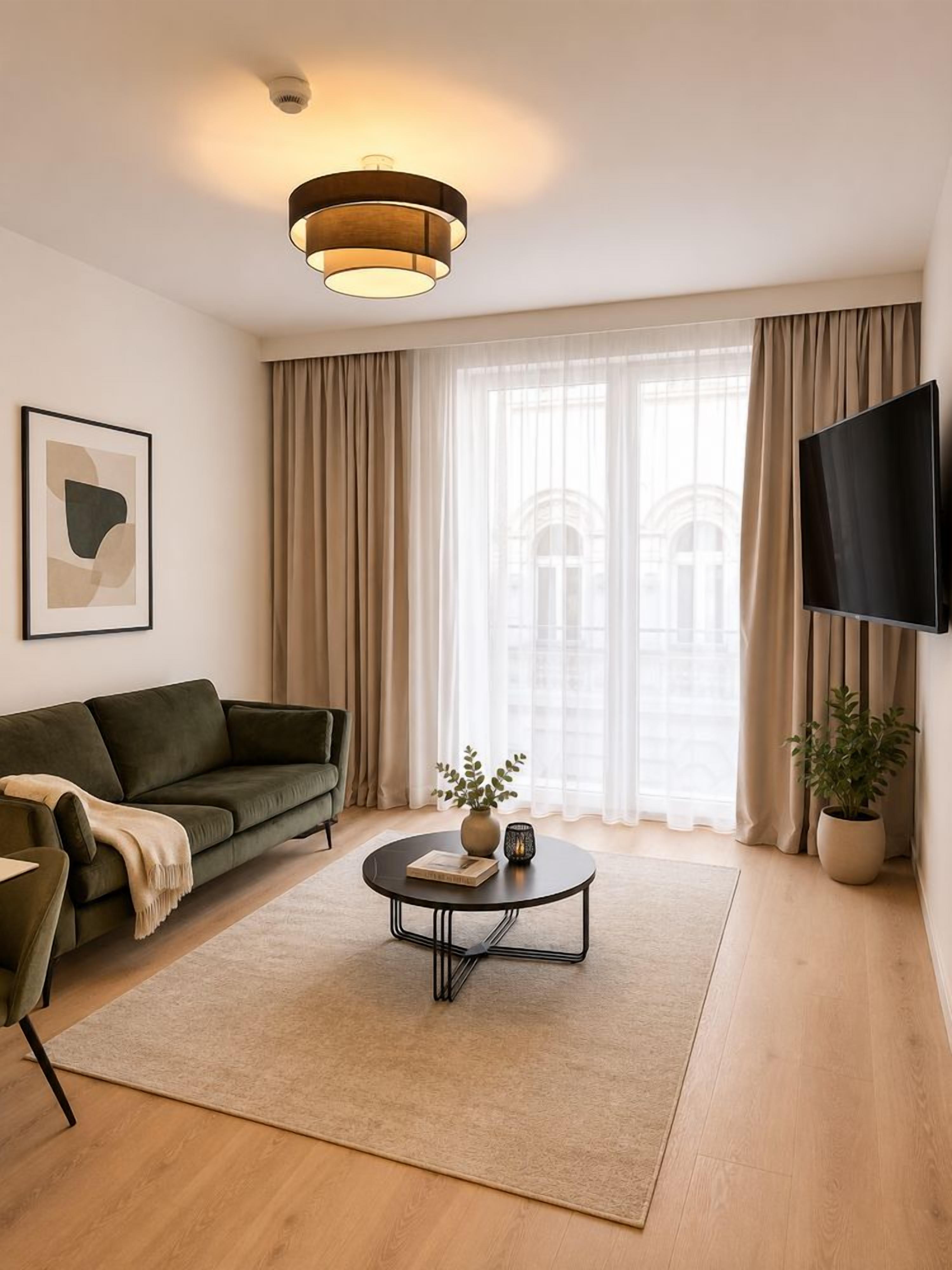 A modern living room with a sofa, coffee table, and a flat-screen TV.
