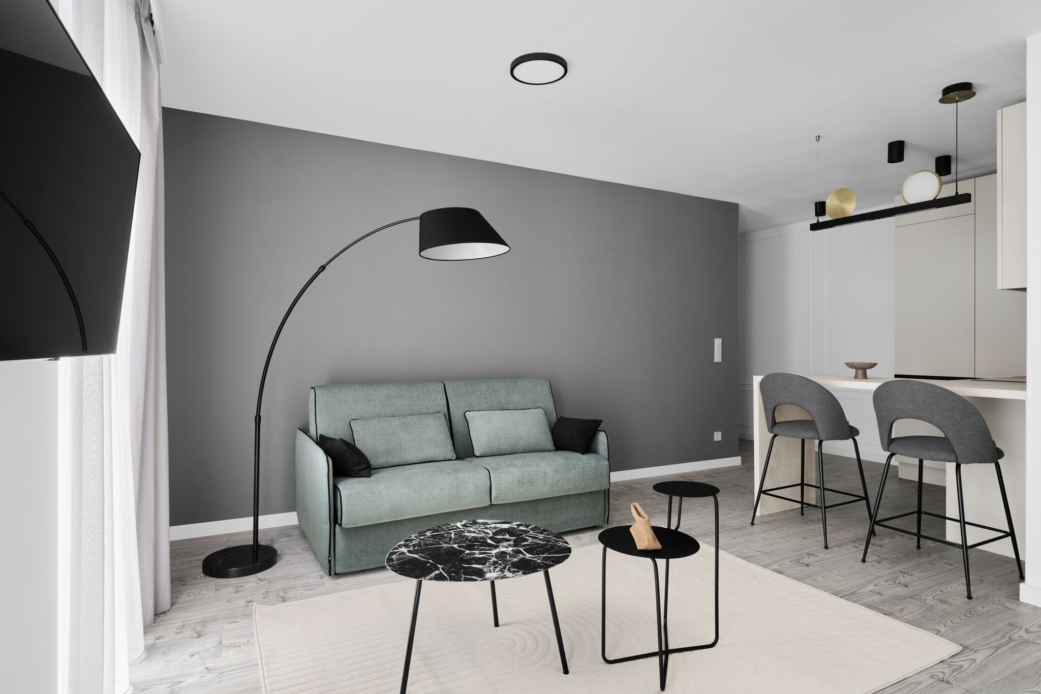 A modern living room with a grey sofa, a black floor lamp, and a round coffee table.