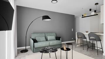 A modern living room with a grey sofa, a black floor lamp, and a round coffee table.