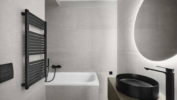 A modern bathroom with a freestanding bathtub, a black towel rack, a round black sink, and a large mirror.