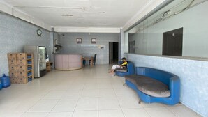 A spacious lobby with a reception desk, a blue sofa, and a refrigerator. - Hotel O California 2NearNagoya Hill Shopping Mall (Batam)