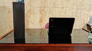 Un mostrador de recepción de madera con una computadora portátil y un estuche negro.