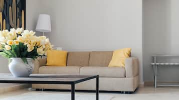 Una sala de estar moderna con un sofá, una mesa de centro y un jarrón de flores.