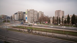 Un immeuble à plusieurs étages doté d’une architecture moderne, caractérisé par une entrée imposante et un espace de stationnement bien visible.
