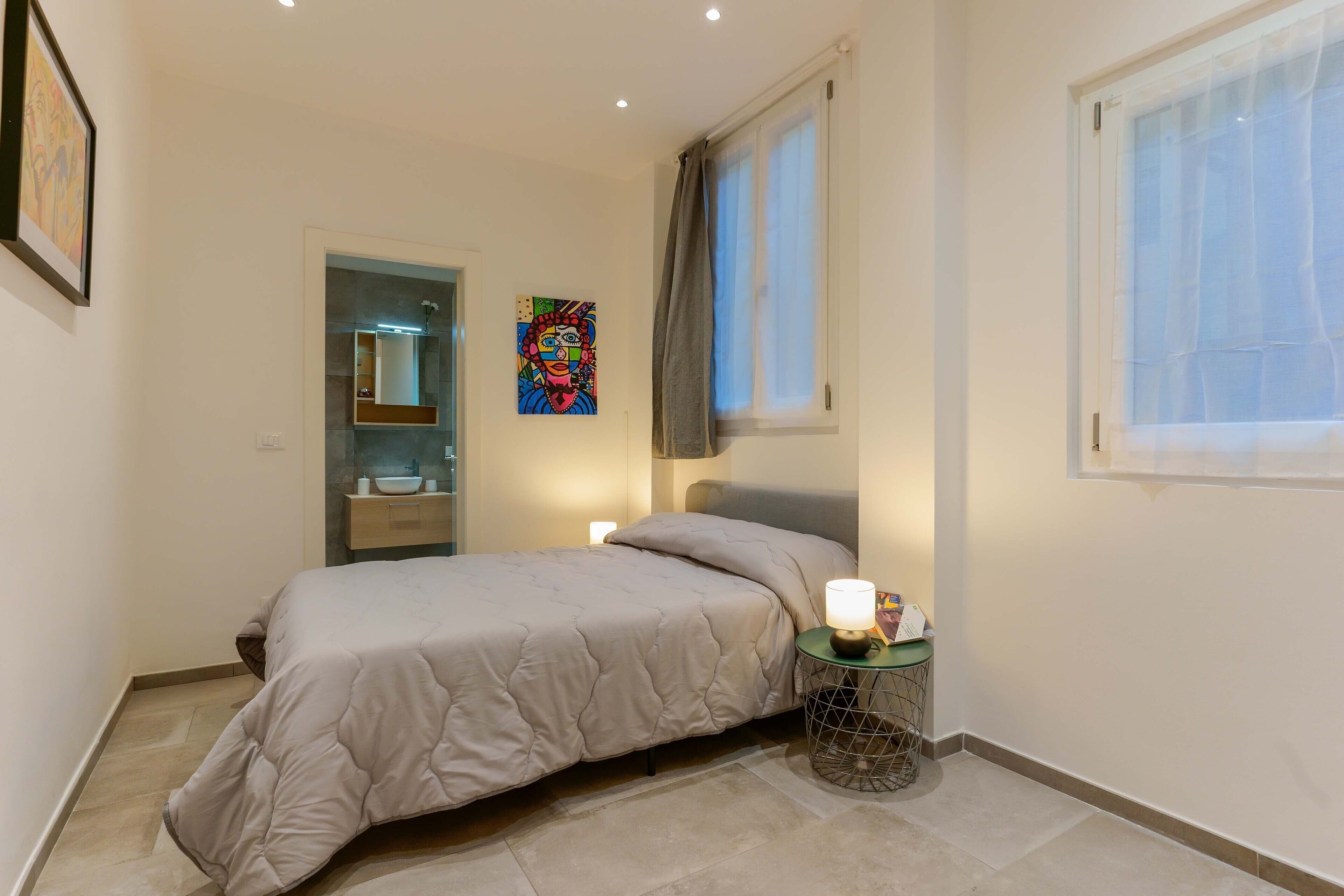 Ein Schlafzimmer mit Bett, Nachttisch und Fenster.