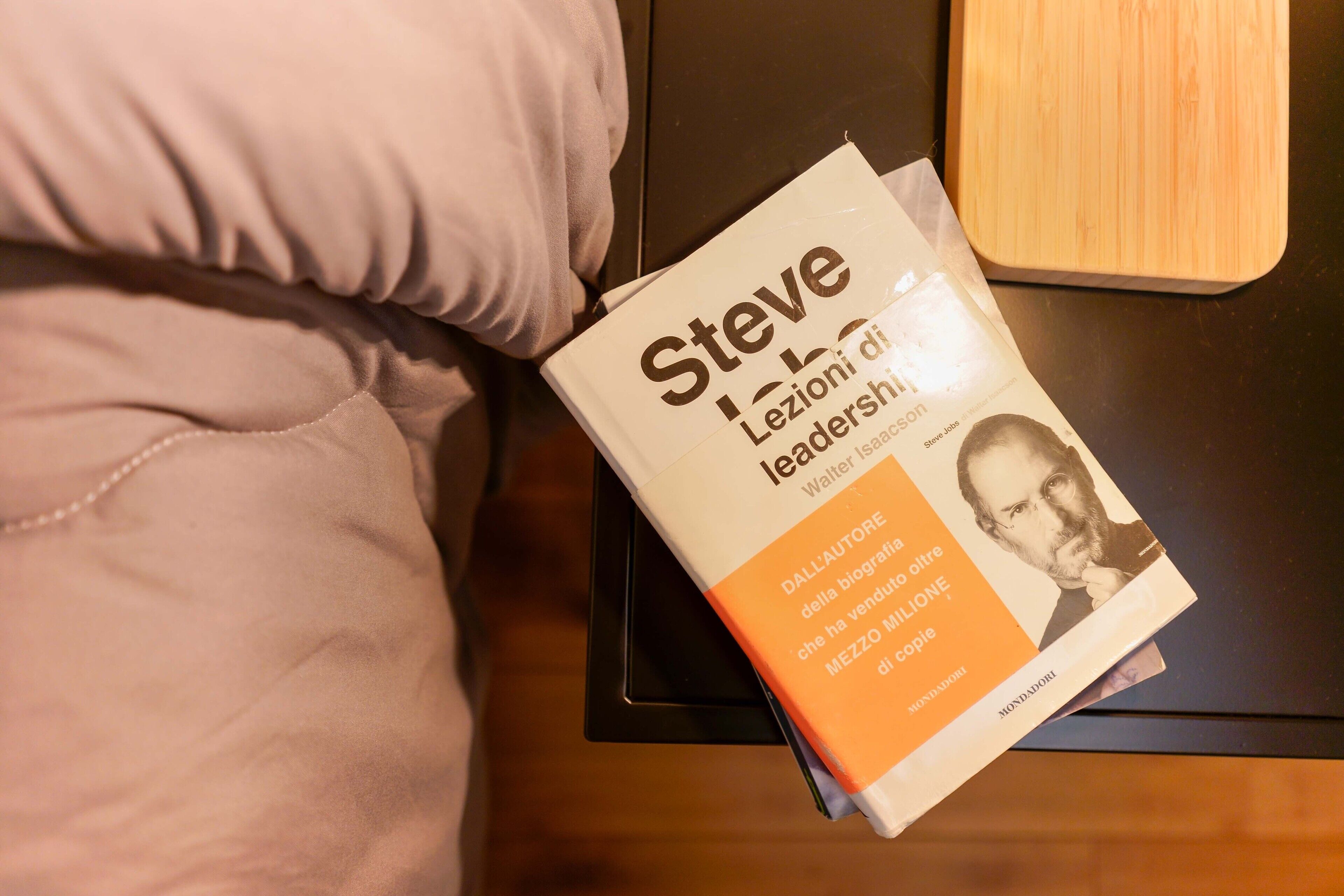 Een boek met de titel 'Steve Lezioni di leadership' op een zwart oppervlak.