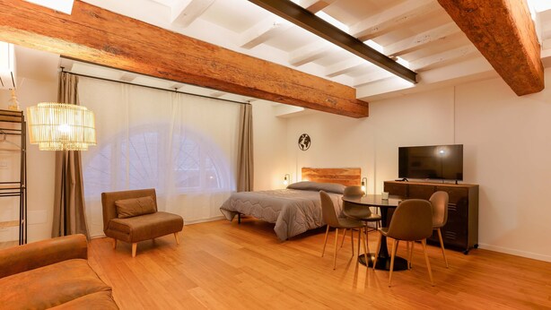 Un dormitorio moderno con cama, escritorio y televisor.