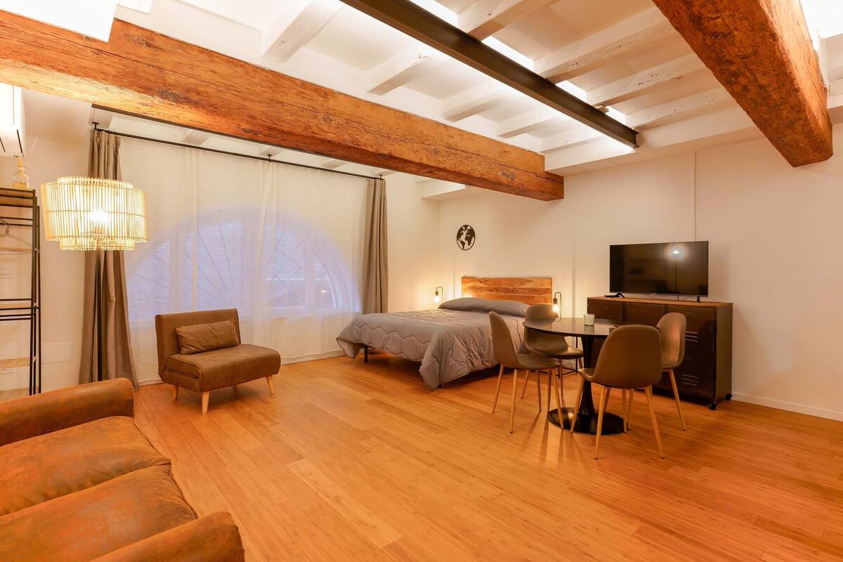 Un dormitorio moderno con cama, escritorio y televisor.