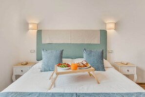 A bed with a tray of breakfast, two pillows, and bedside tables. - COLOMBO APARTMENTS (Lido di Camaiore)