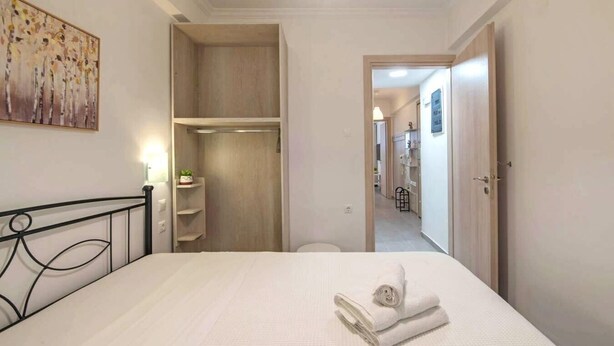 Een slaapkamer met een bed, een kledingkast en een gang naar een badkamer.