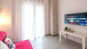 Ein modernes Wohnzimmer mit einem an der Wand befestigten Flachbildfernseher, der eine Streaming-Dienstanwendung zeigt.