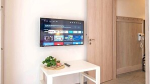 Ein an der Wand befestigter Flachbildfernseher, der verschiedene Streaming-Dienste anzeigt.