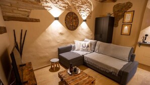 A cozy living room with a sofa, a coffee table, and a decorative wall clock.