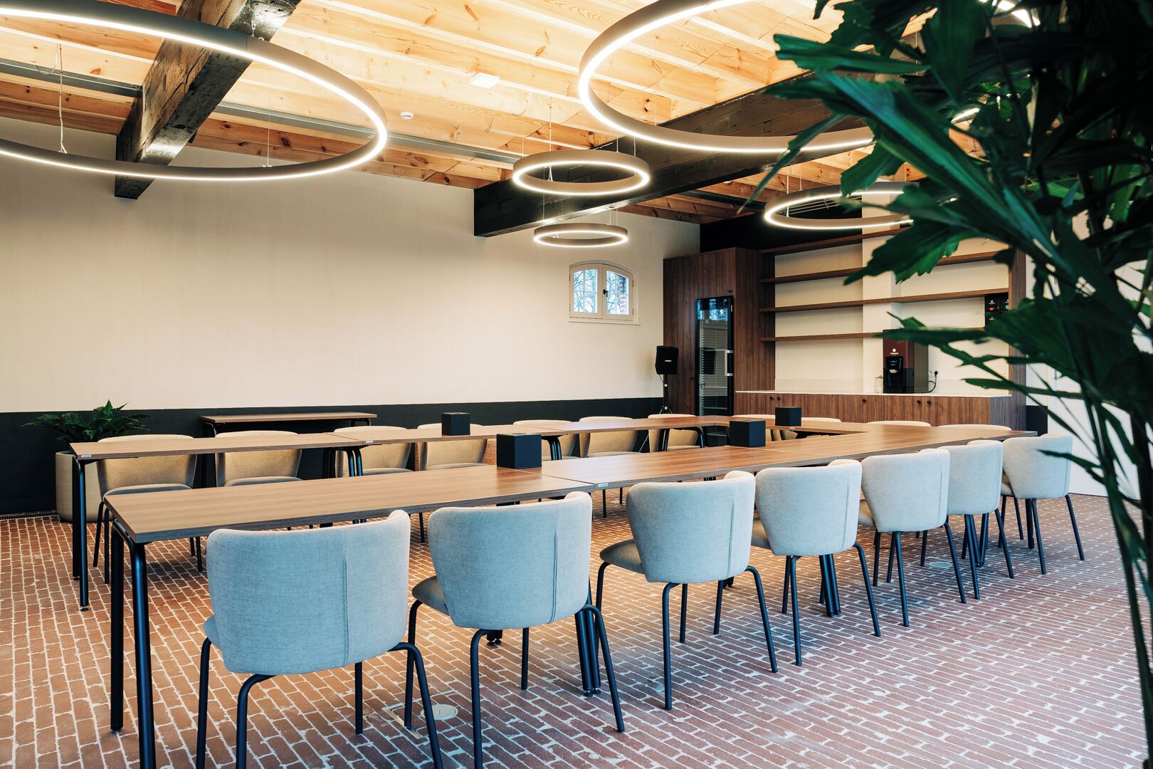 Une salle de conférence équipée d’une longue table, de chaises et d’un système audio.