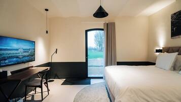 Une chambre d’hôtel moderne équipée d’un lit, d’un bureau, d’une télévision et offrant une vue sur l’extérieur.