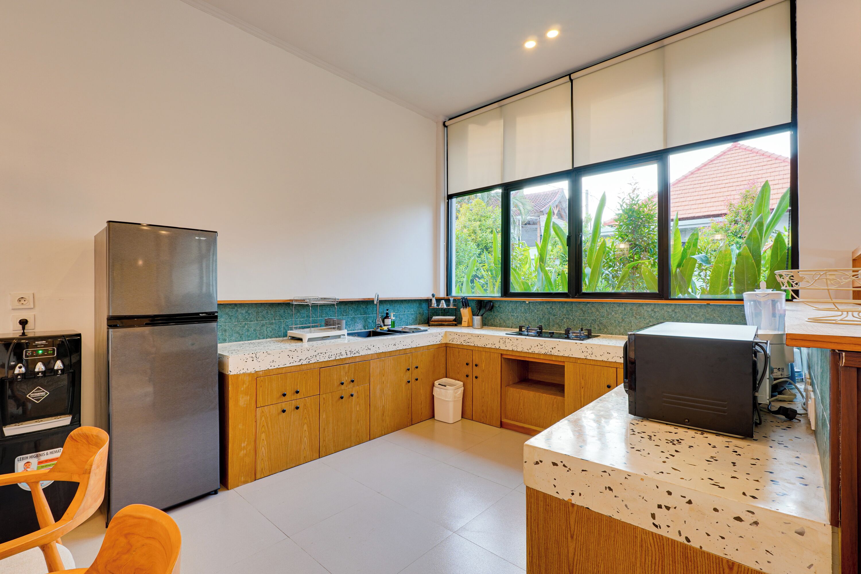 A modern kitchen with a refrigerator, sink, and countertop appliances.