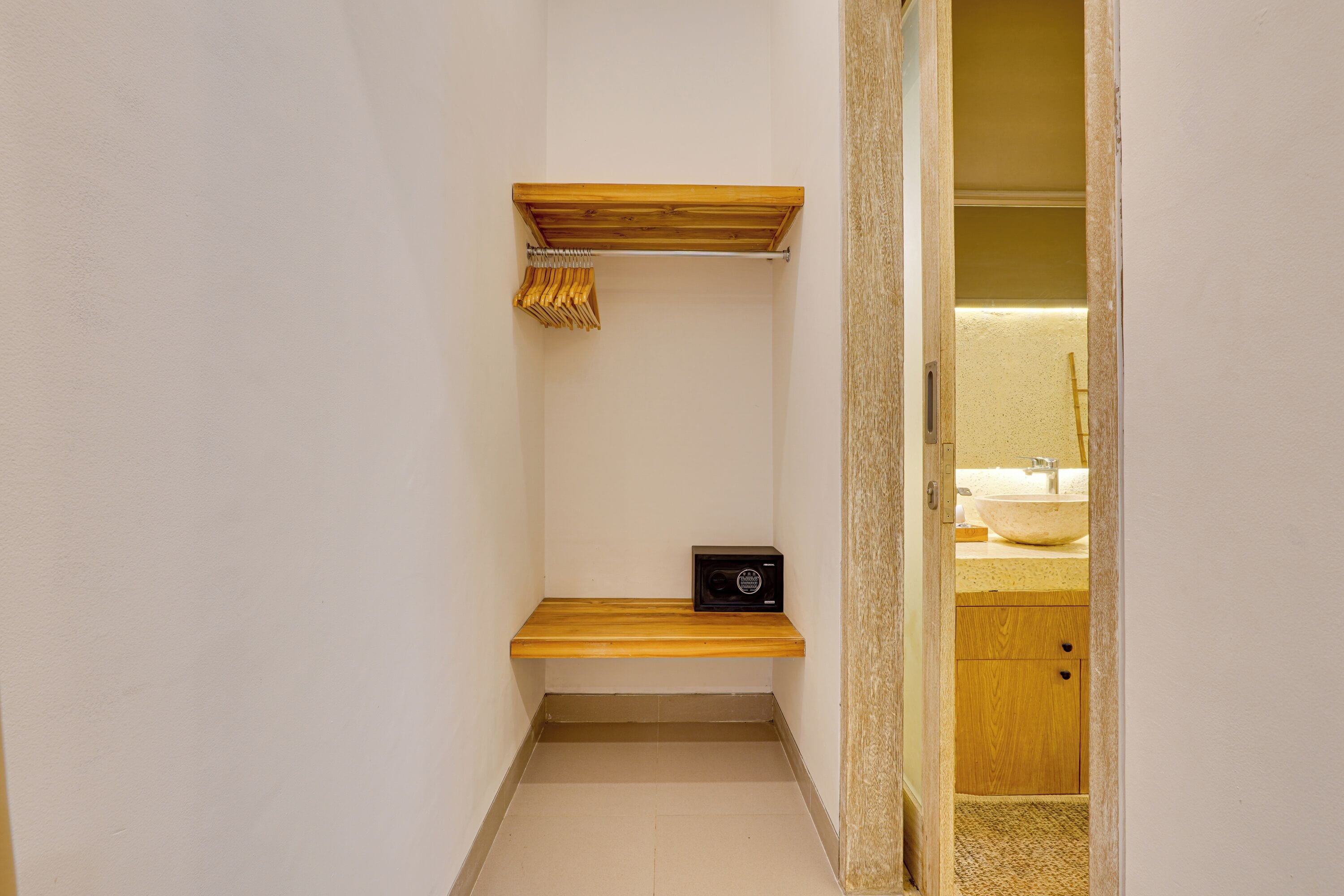A small bathroom with a wooden shelf, a towel rack, and a radio.