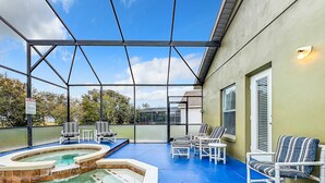 Una piscina exterior techada con sillas de descanso y un jacuzzi.