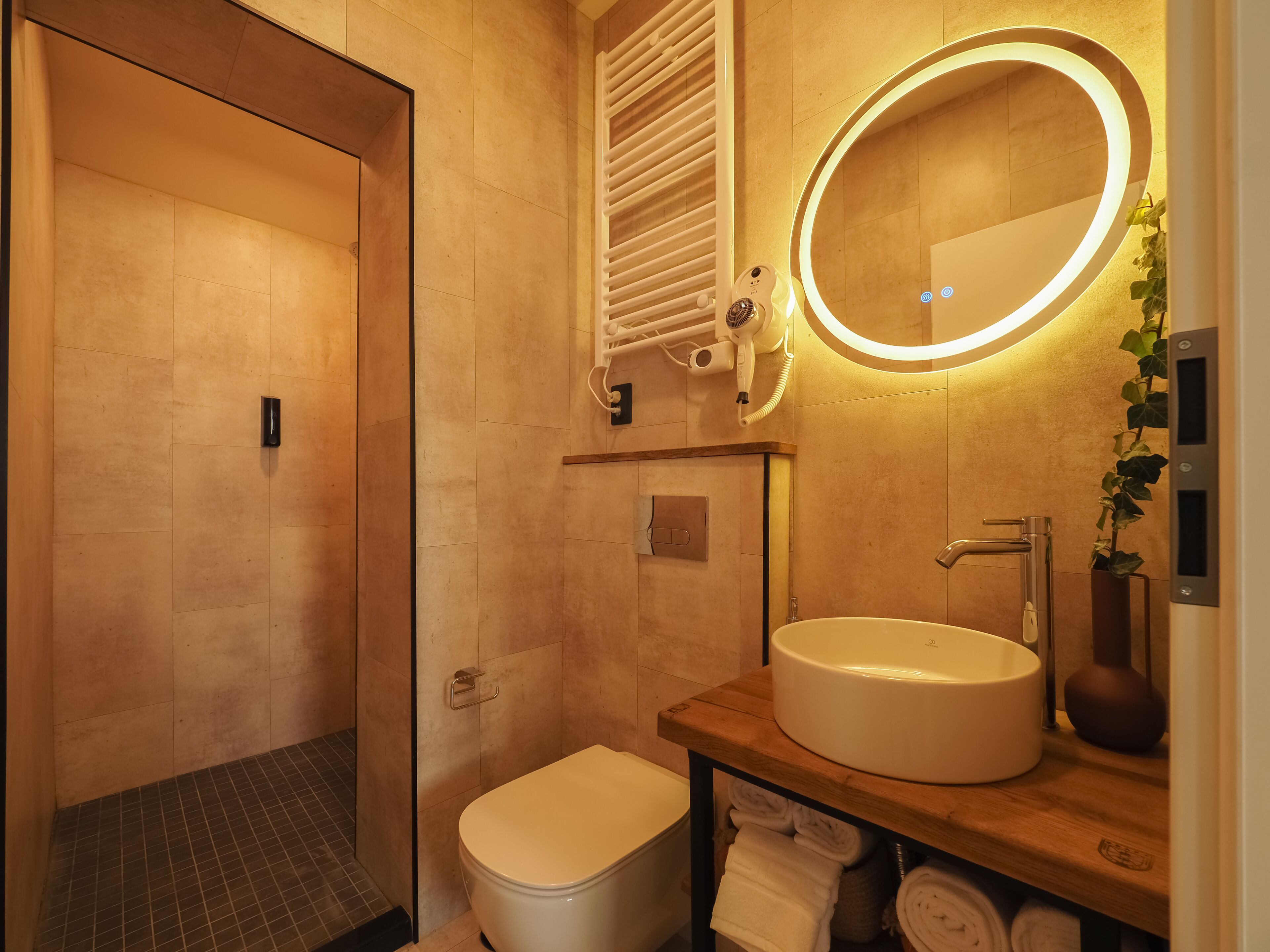 A modern bathroom with a toilet, sink, and mirror.