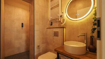 A modern bathroom with a toilet, sink, and mirror.