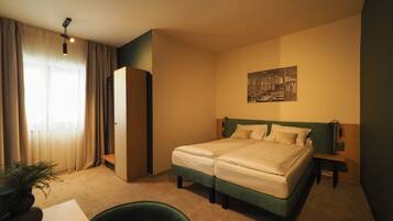 Habitación de hotel con cama doble, escritorio, silla, armario y un cuadro en la pared.