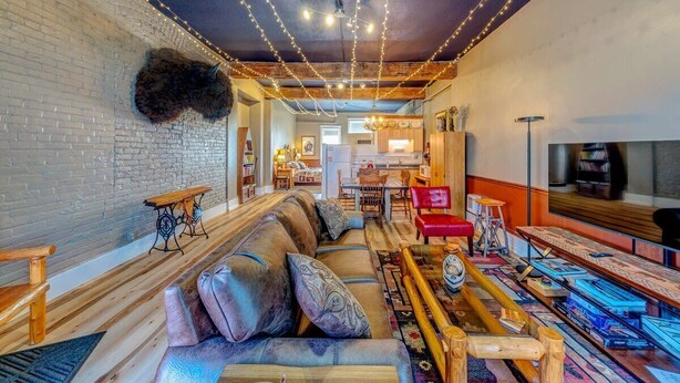 Ein gemütliches Wohnzimmer mit einer Couch, einem Holztisch und Lichterkette.