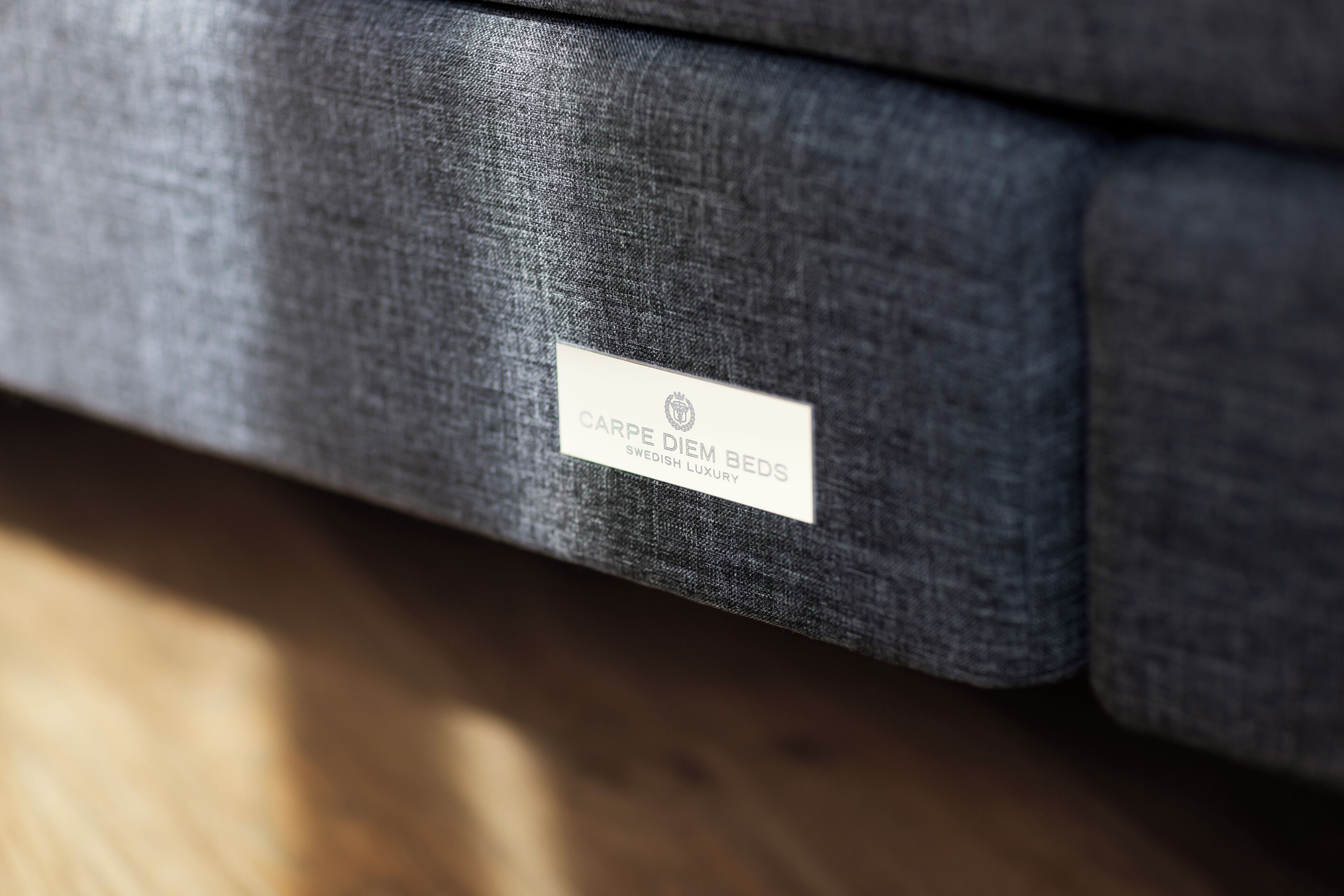 A label on a piece of furniture with the text "CARPE DIEM BEDS SWEDISH LUXURY".