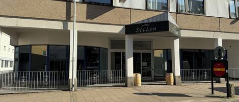A hotel named 'Sillen' with a modern facade, large windows, and a gated entrance.