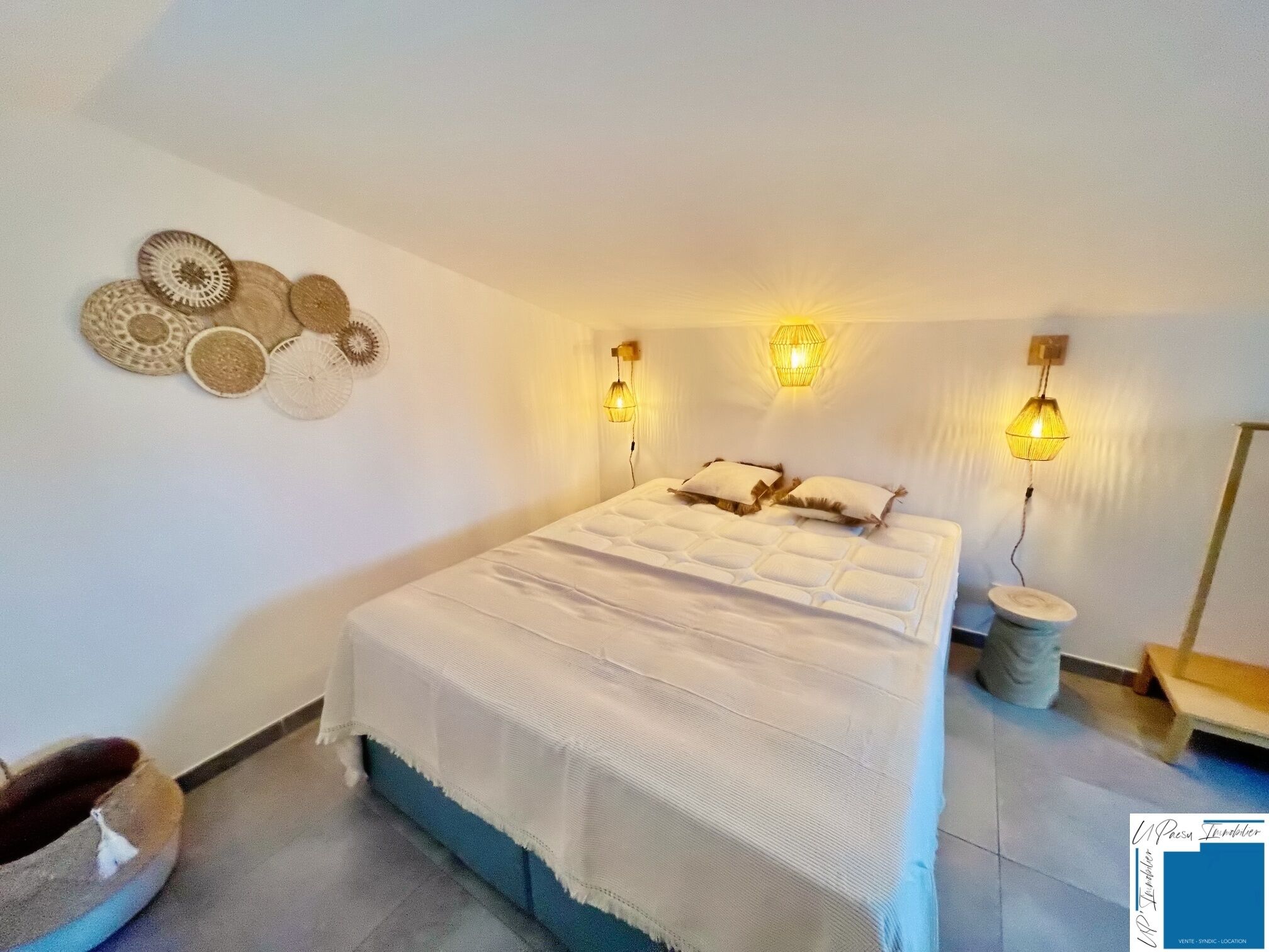 Un dormitorio con una cama, dos lámparas de pared y decoración mural.
