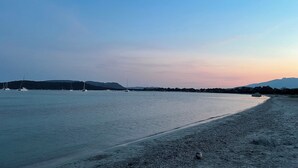 A beach with a calm sea, boats, and distant hills. - villa Suera - 2 Bedrooms - Pools - Air Conditioning (Lecci)